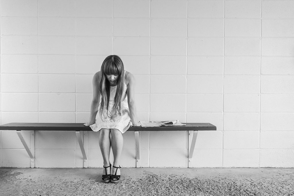 A woman sitting on top of a bench.