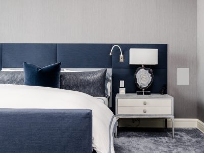 A bedroom with blue headboard and white bed