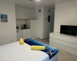 A bed room with a white bed and tv