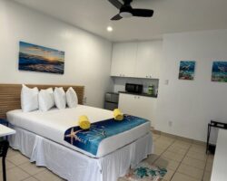 A bed room with a white bed and blue blanket